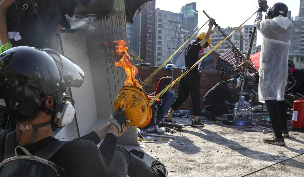 Người biểu tình trong trường dùng ná bắn bom xăng vào cảnh sát. Ảnh: SCMP