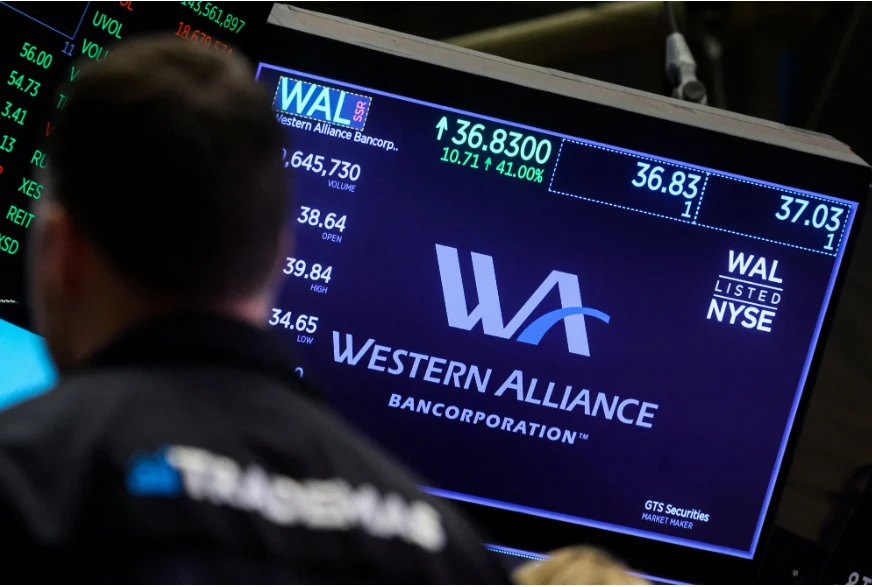 Một màn hình hiển thị logo và thông tin giao dịch của NH khu vực Western Alliance Bancorporation trên sàn của Sở Giao dịch Chứng khoán New York (NYSE) ở TP New York vào ngày 14-3. Sau sự sụp đổ của NH Silicon Valley, Moody's đã hạ triển vọng tín nhiệm đối với toàn bộ hệ thống NH Mỹ và đặt Western Alliance Bancorporation cùng nhiều NH khác vào danh sách theo dõi. Ảnh: REUTERS