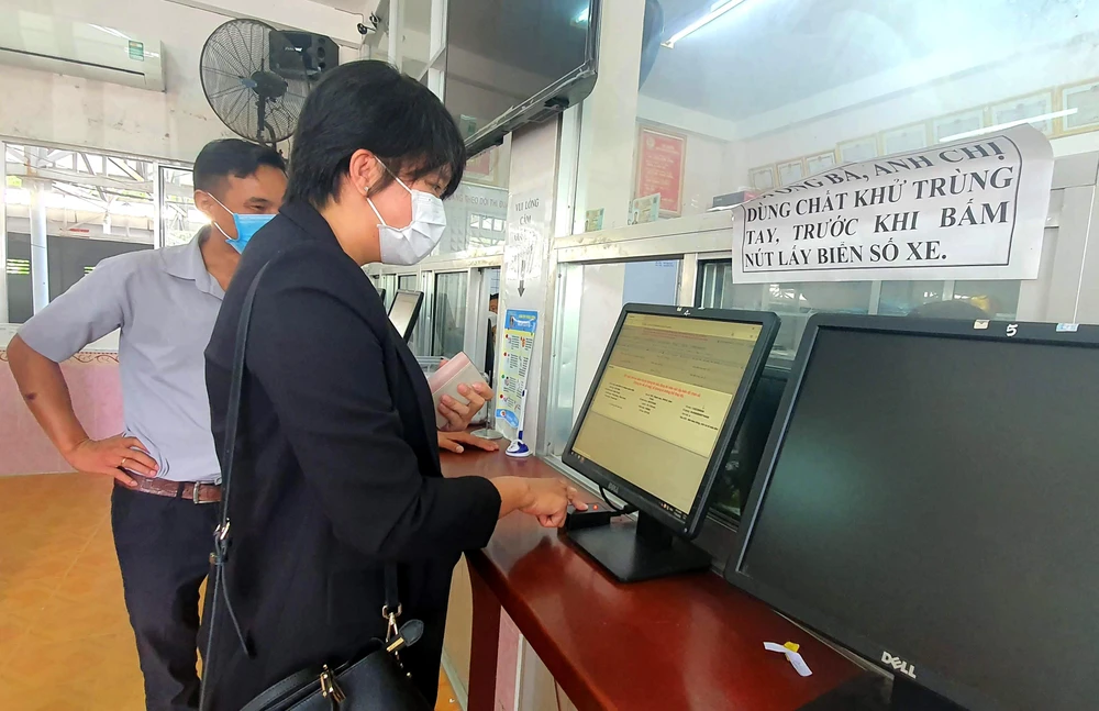 Người dân bấm nút lấy biển số xe tại Phòng CSGT Công an tỉnh Ninh Thuận. Ảnh: HUỲNH HẢI.