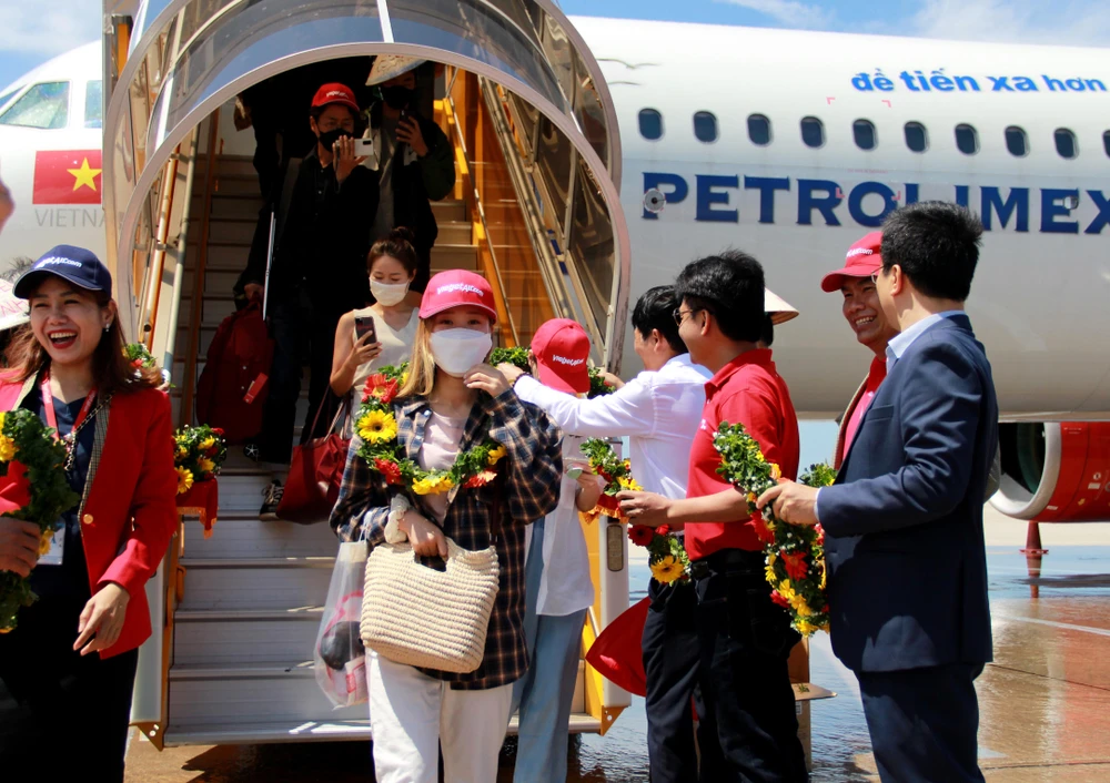 Du khách Hàn Quốc được tặng hoa và quà lưu niệm khi đặt chân đến Nha Trang. Ảnh: PS.