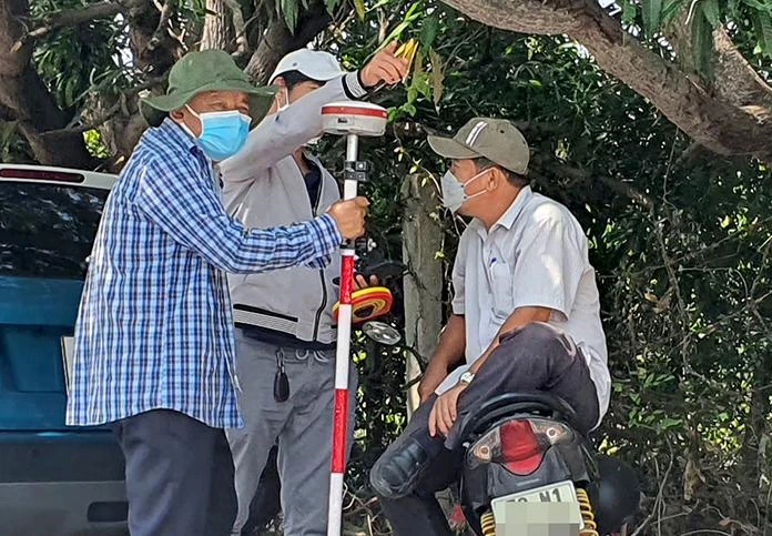 Nhân viên địa chính đo đạc kiểm kê đất đai tại huyện Cam Lâm phục vụ cho công tác quy hoạch Khu đô thị mới. Ảnh: HUỲNH HẢI.
