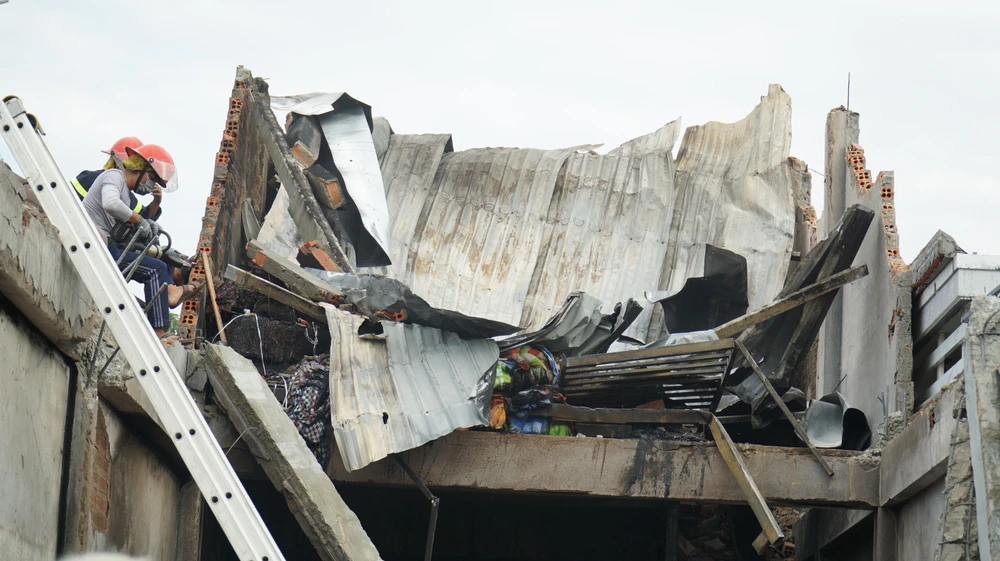 Cảnh sát PCCC cắt các cột có nguy cơ sụp đổ để vào hiện trường tìm kiếm nạn nhân. Ảnh: HH