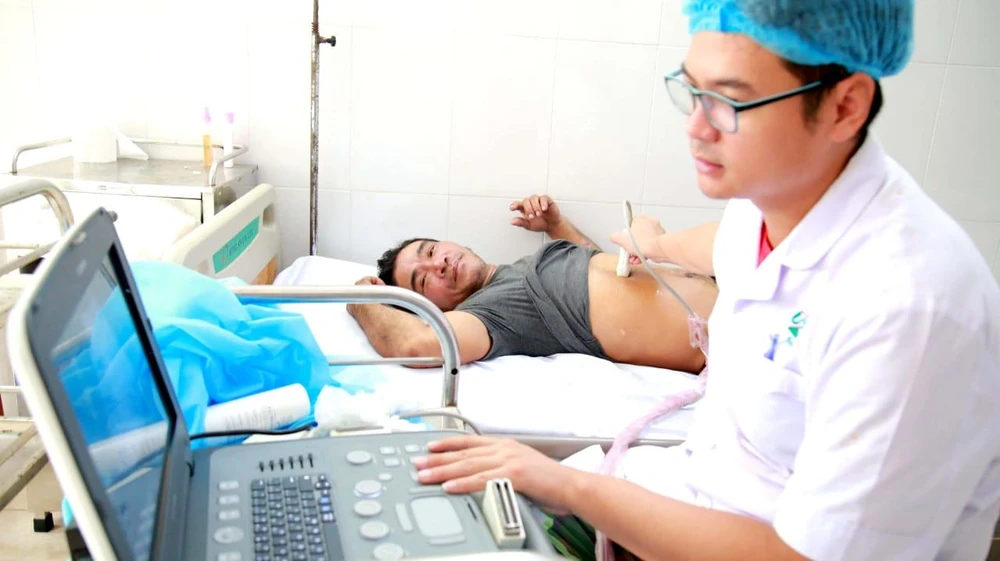 Các bác sĩ ở đảo Trường Sa cấp cứu cho ngư dân Trầm. Ảnh: NGUYỄN NINH