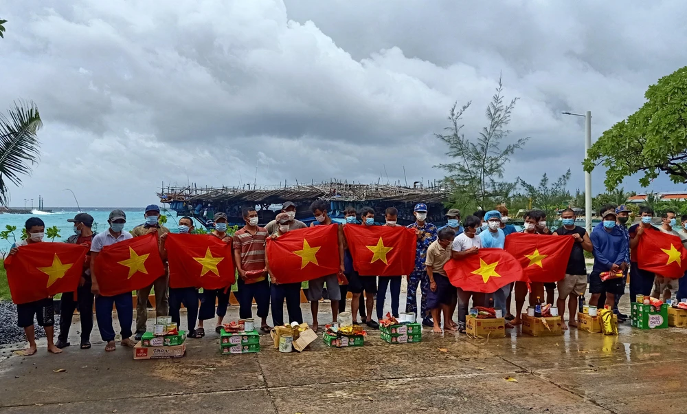 Hải quân tặng cờ và quà cho ngư dân trong bão số 4. Ảnh: HẢI QUÂN