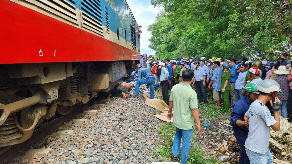 Lực lượng chức năng đưa thi thể nạn nhân bị mắc kẹt dưới đoàn tàu ra ngoài. Ảnh: NT.