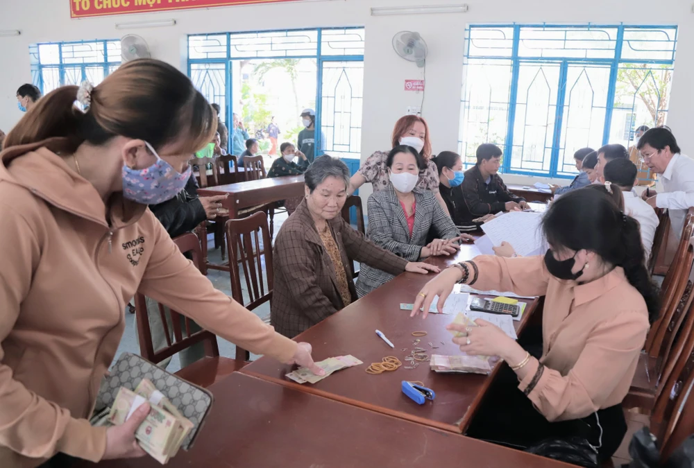 Người dân nhận tiền bồi thường nứt nhà do thi công Quốc lộ 1. Ảnh: NÚI XANH.