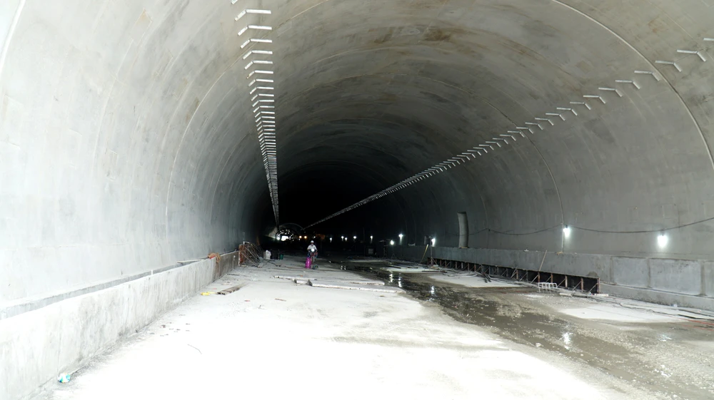 Đơn vị thi công đã hoàn thành gia cố cửa hầm, đào tường hầm, vòm hầm. Hiện ống hầm trái đang được hoàn thiện chống thấm, bê tông cốt thép vỏ hầm. Một mũi thi công khác cũng đang thi công tại tuyến ống phải. 1.000 người ngày đêm hoàn thiện cao tốc Nha Trang - Cam Lâm