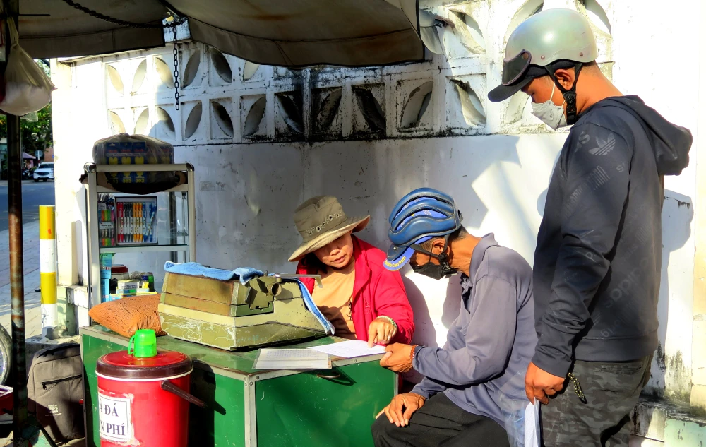 Bà Thư tận tình hỏi thông tin để làm đơn cho khách. Ảnh: CHU VÂN