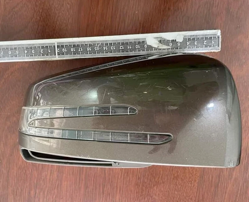 Ốp gương chiếu hậu của ô tô rơi ở hiện trường. Ảnh: CA