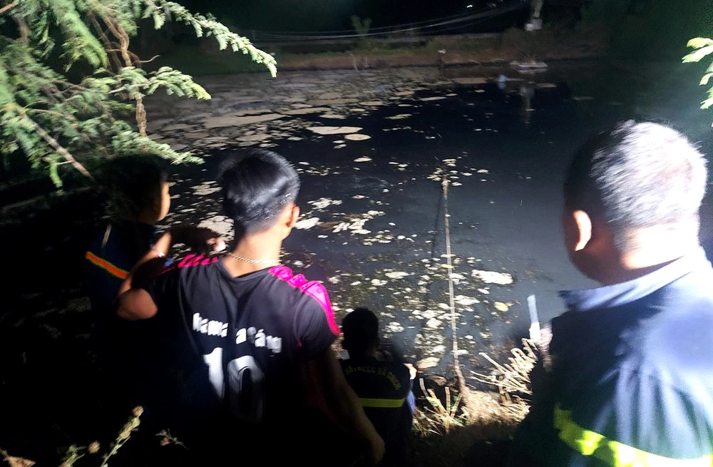 Lực lượng chức năng tìm kiếm nạn nhân trong hồ chứa nước thải. Ảnh: Đ.C