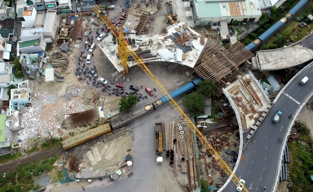 Theo ghi nhận của PV sáng 14-3, chủ đầu tư vẫn chưa có biện pháp bảo đảm an toàn cho người đi đường mà vẫn tiến hành thi công bình thường. Giờ cao điểm hoặc những lúc đoàn tàu lửa đi qua, dòng xe cộ vẫn len lỏi chen nhau đi dưới cần cẩu khổng lồ và những thanh sắt lớn.