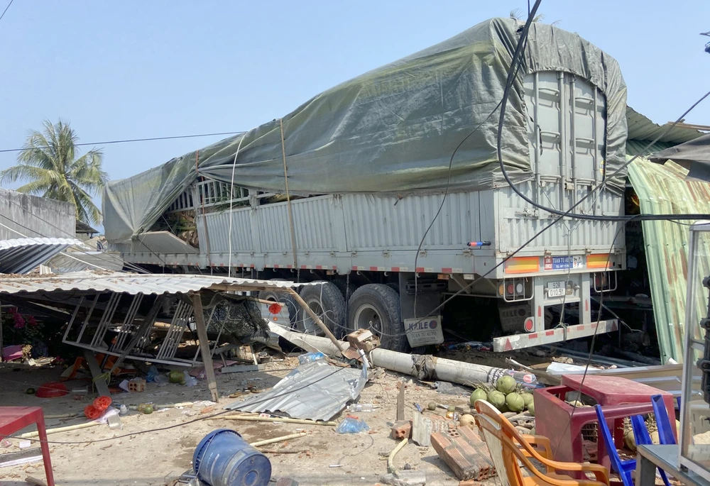 Chiếc xe tải chở dừa tông sập nhà dân sau khi tránh các ống thép rơi xuống đường. Ảnh: T.Q