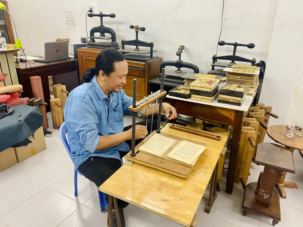 Vị "bác sĩ sách" đang khâu lại một cuốn sách cũ. Ảnh: CHU VÂN Vị "bác sĩ sách" đang khâu lại một cuốn sách cũ. Ảnh: CHU VÂN