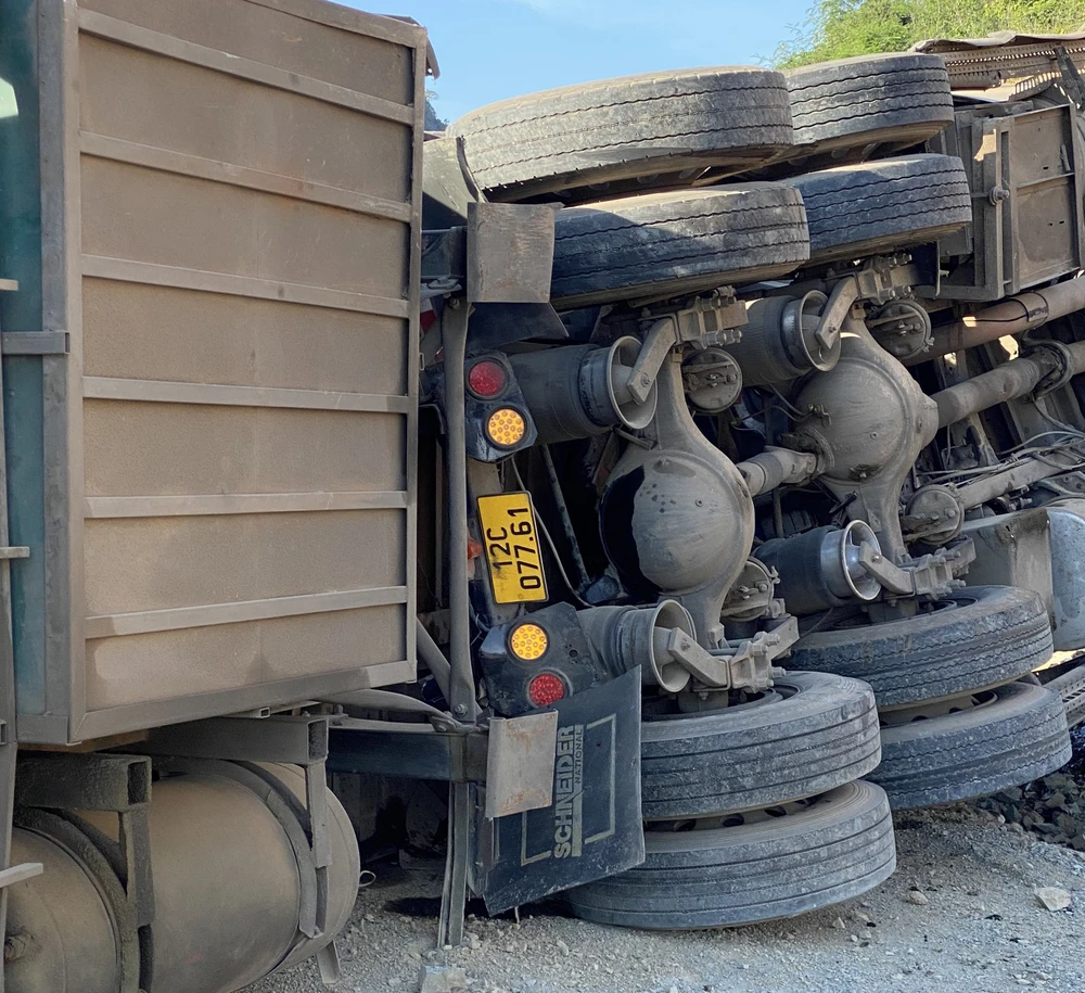 Sau khi va chạm với ô tô, xe container tiếp tục lao vào lan can rồi lật nghiêng bên đường.