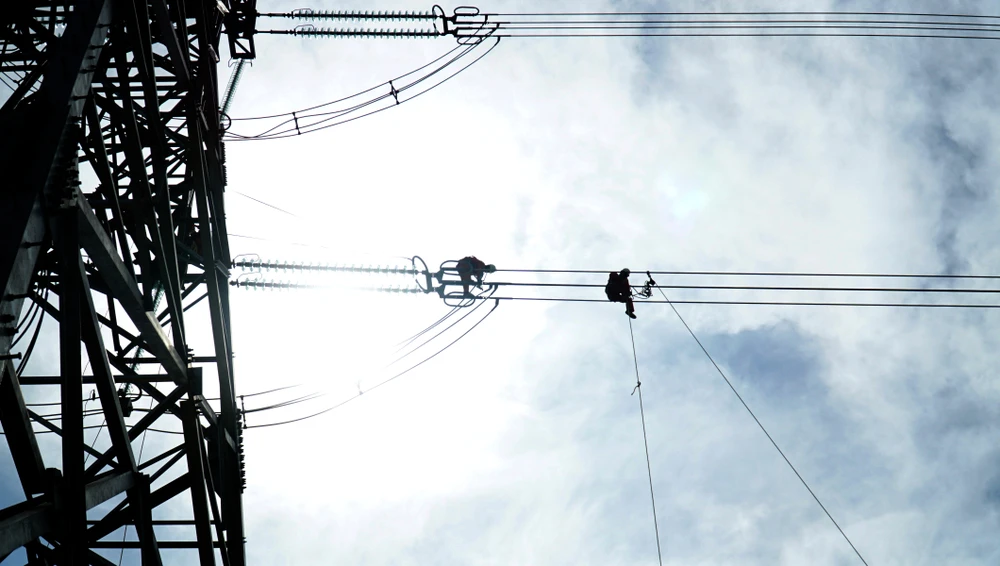 Sau đó, kỹ thuật xử lý tình huống căng lại đường dây do bị ảnh hưởng của gió bão. Ảnh: H.H