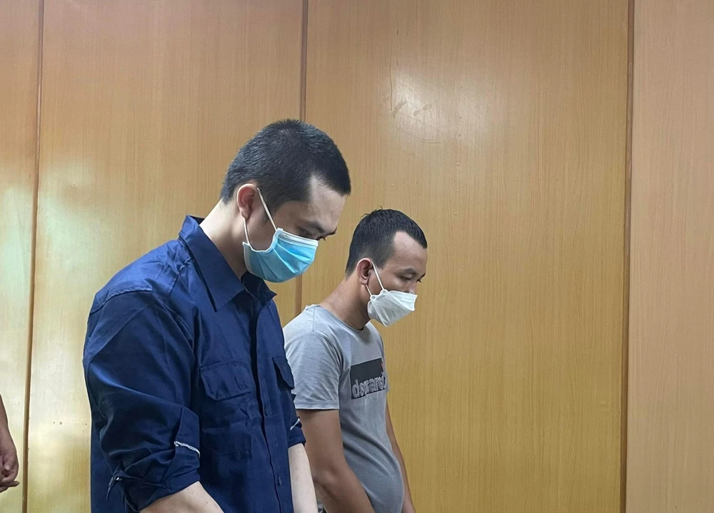 Hai bị cáo Luân (áo xanh) và Toản nghe tòa tuyên án. Ảnh: HOÀNG YẾN