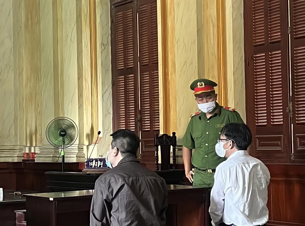 Bị cáo Diệp Dũng (áo trắng) và bị cáo Bắc ngồi chờ HĐXX vào phòng xử. Ảnh: HOÀNG YẾN