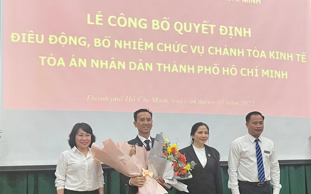 Chánh án TAND TP.HCM Lê Thanh Phong trao quyết định bổ nhiệm cùng hai nữ phó Chánh án tặng hoa chúc mừng ông Đạt. Ảnh: HOÀNG YẾN