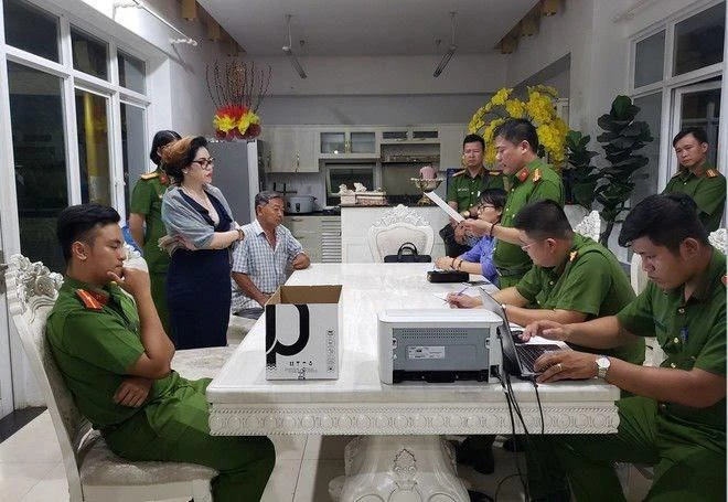 Công an đọc lệnh bắt Phạm Thị Tuyết Nhung. Ảnh: CACC