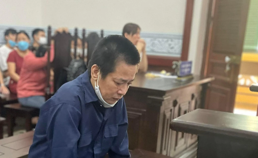 Bị cáo Ngọc cúi mặt, xa xa người vợ khóc mỗi khi nghe nói đến hành vi phạm tội của chồng với con. Ảnh: H.YẾN