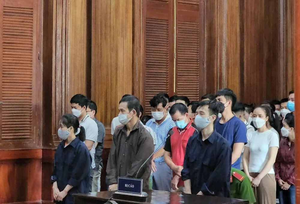 Các bị cáo đứng trong phần thủ tục khai mạc phiên xử. Ảnh: H.YẾN