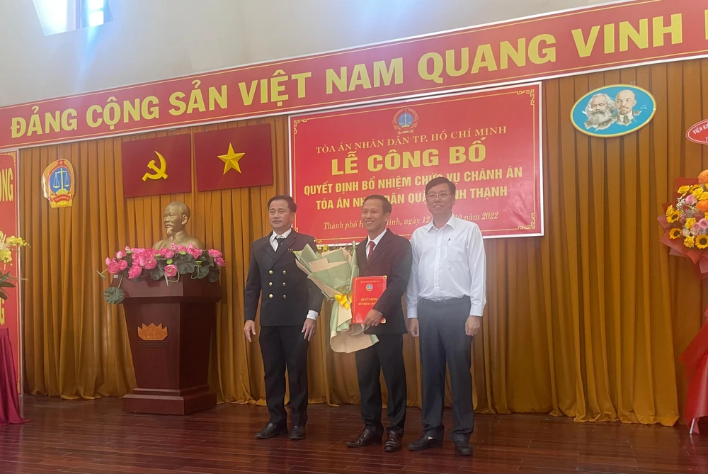 Chánh án TAND TP.HCM Lê Thanh Phong và lãnh đạo địa phương trao quyết định bổ nhiệm và tặng hoa chúc mừng Tân Chánh án. Ảnh: H.YẾN