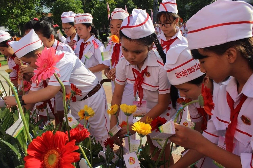 Các em dâng hoa, báo công với Bác Hồ kính yêu về những việc làm đã đạt được trong năm học vừa qua.