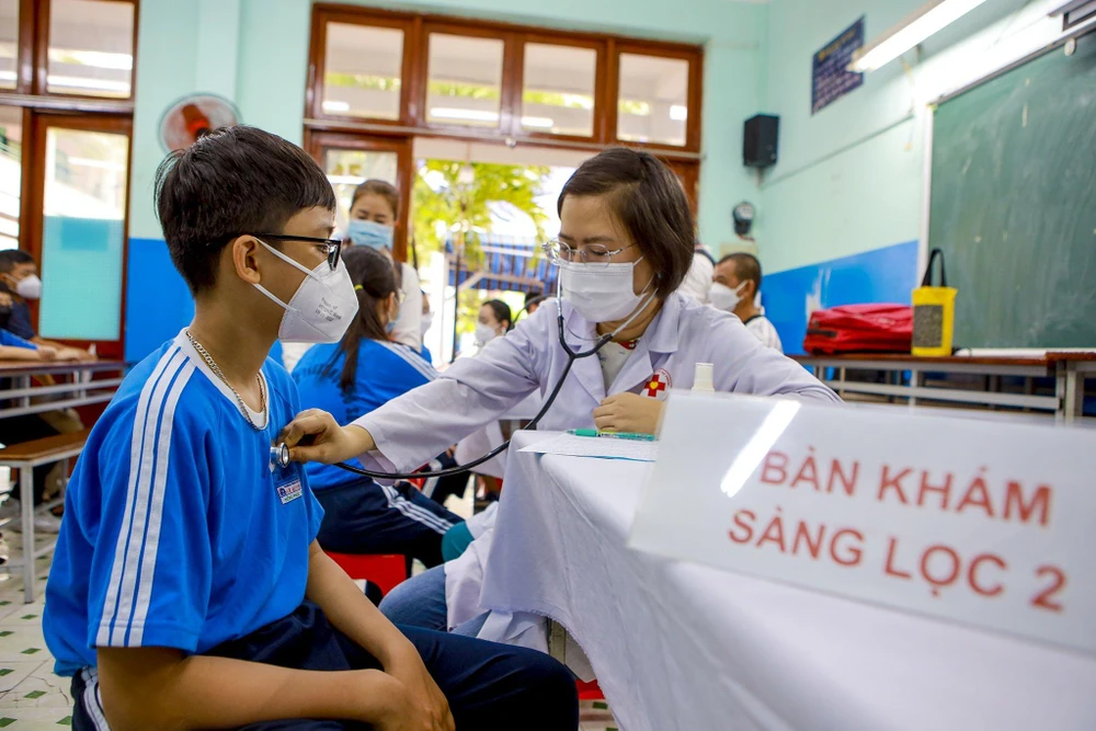 Học sinh lớp 6 trường THCS Lê Quý Đôn được cho khám sàng lọc trước khi tiêm chủng COVID-19. Ảnh: NGUYỆT NHI