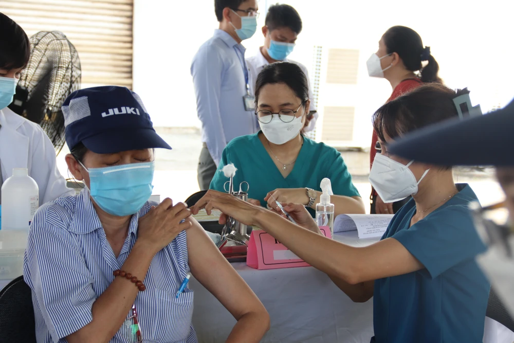 Công nhân Công ty Juki Việt Nam tiêm vaccine mũi 3, mũi 4 sáng 14-6. Ảnh: HL