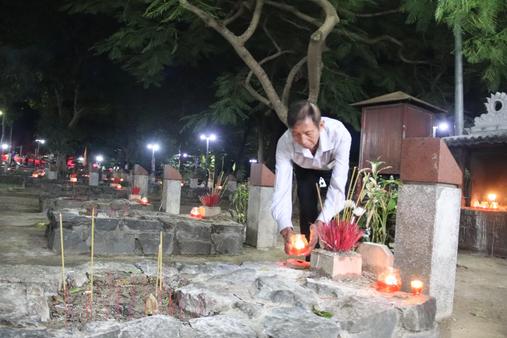 Ông Nguyễn Kim Quang thắp hương viếng mộ cha mình là liệt sĩ Nguyễn Văn Trí.