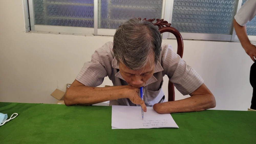 Bị thương ở hai tay, ông vẫn cố gắng tập viết để tự phục vụ công việc của mình. Ảnh: THANH TRANG