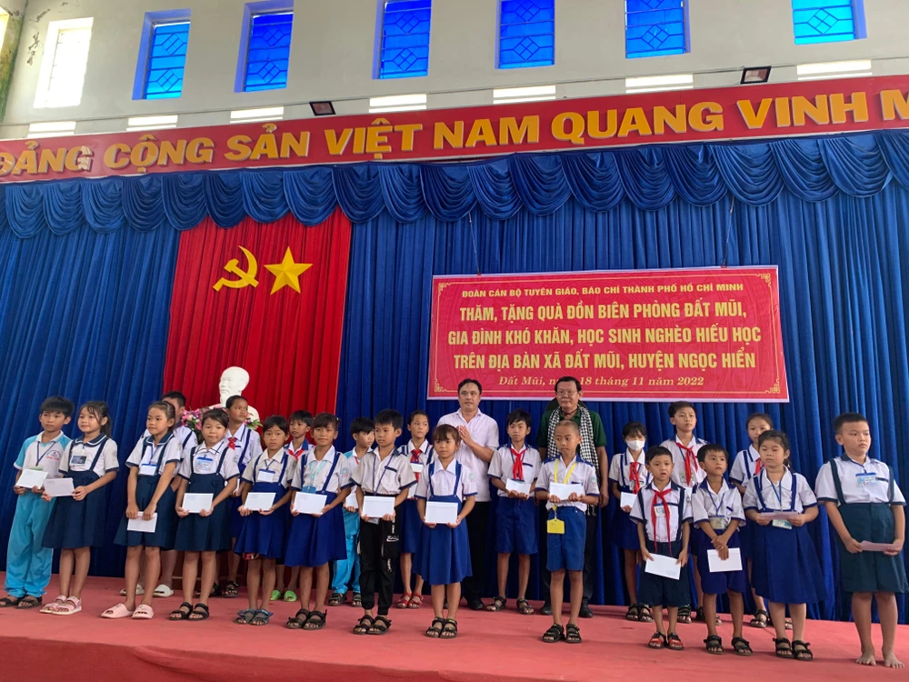 Ông Nguyễn Tấn Phong và ông Trương Văn Sệ tặng quà cho các học sinh khó khăn. Ảnh: H.LAN