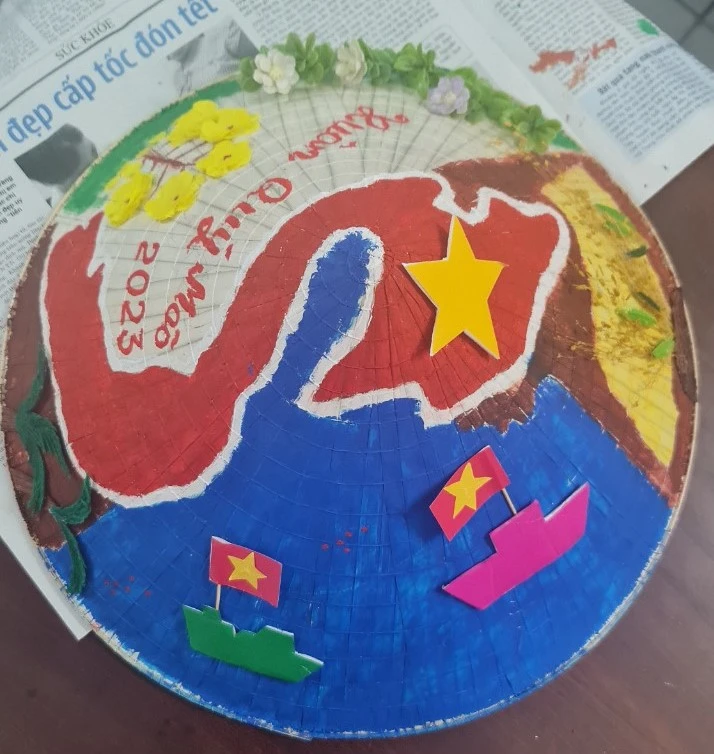 Bức vẽ trên nón lá về biển đảo và các chấm nhỏ thể hiện các quần đảo của Việt Nam. Ảnh: GDCC