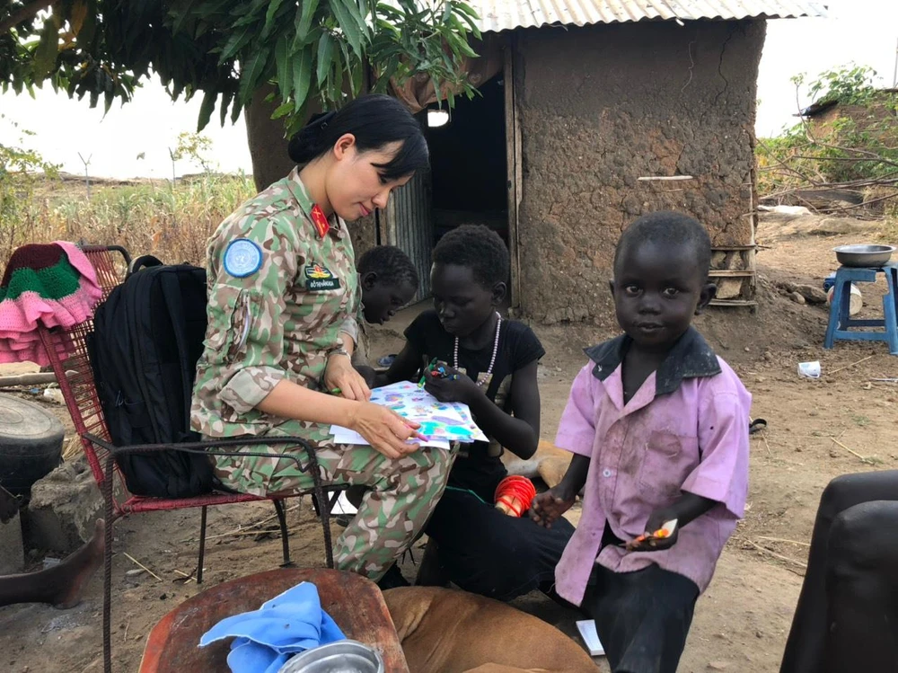 Trung tá Đỗ Thị Hằng Nga tặng một số hộp màu, giấy để các em vẽ những ước mơ về tương lai của mình. Ảnh: GGHBVN