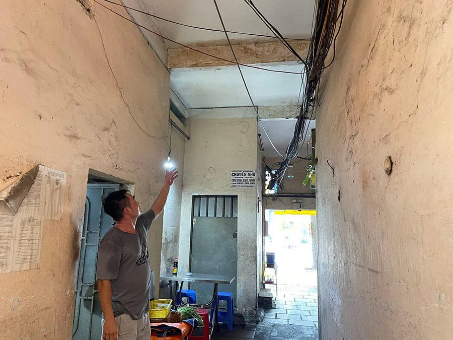 Người dân tại chung cư 137 Lý Thường Kiệt chỉ lên tấm đà ngay cổng ra vào chung cư thường xuyên bị nước nhỏ xuống lối đi suốt nhiều năm nay. Ảnh: VIỆT HOA