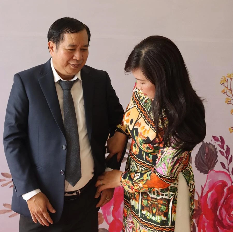 Chị Thái “nâng khăn sửa túi” cho chồng trong lần đi nhận bằng khen tuyên dương 30 năm gia đình hạnh phúc. Ảnh: NVCC
