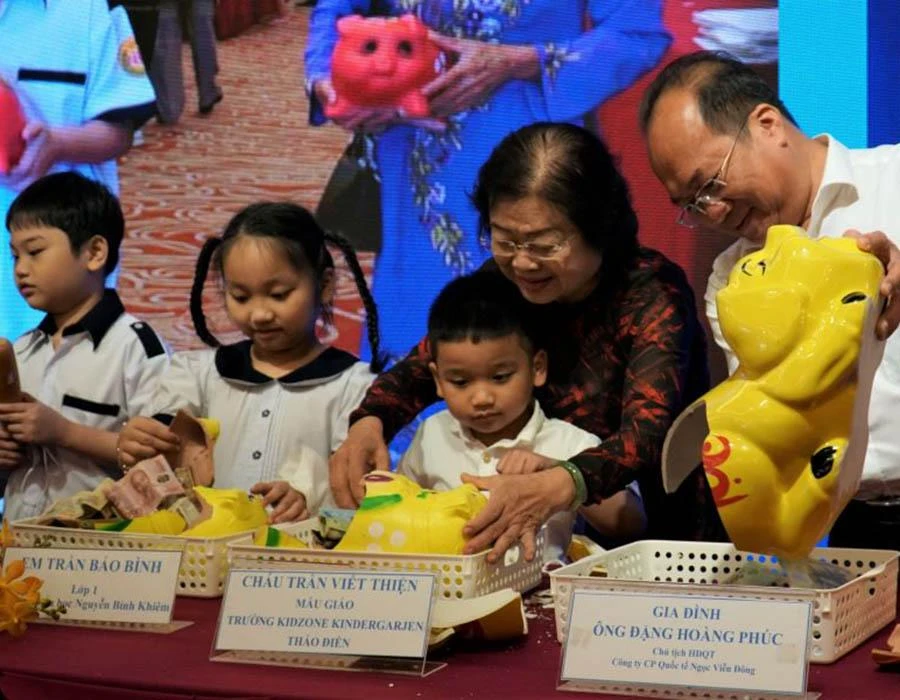 Bà Trương Mỹ Hoa cùng các gia đình hân hoan mổ heo đất tiết kiệm tại buổi thông tin các hoạt động kỷ niệm “Hành trình 10 năm vì Hoàng Sa - Trường Sa thân yêu”. Ảnh: BẢO PHƯƠNG