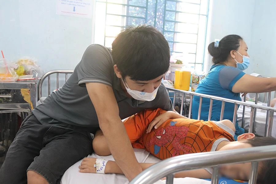 Anh Lê Đăng Bé đang chăm sóc con trai tại Khoa nhiễm - thần kinh BV Nhi đồng 1. Ảnh: HOÀNG LAN Anh Lê Đăng Bé đang chăm sóc con trai tại Khoa nhiễm - thần kinh BV Nhi đồng 1. Ảnh: HOÀNG LAN