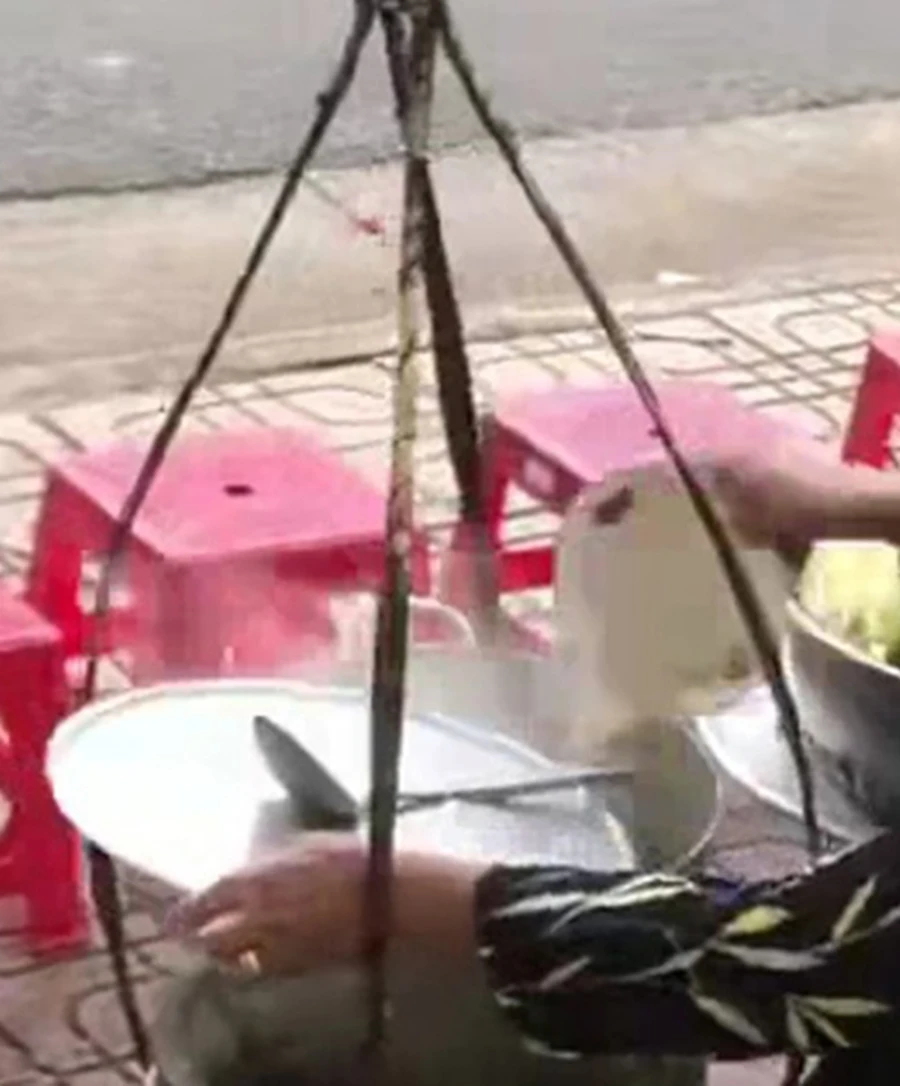 Hình ảnh được cho là người phụ nữ đổ tô nước thừa vào nồi nước lèo. (Ảnh cắt từ clip)