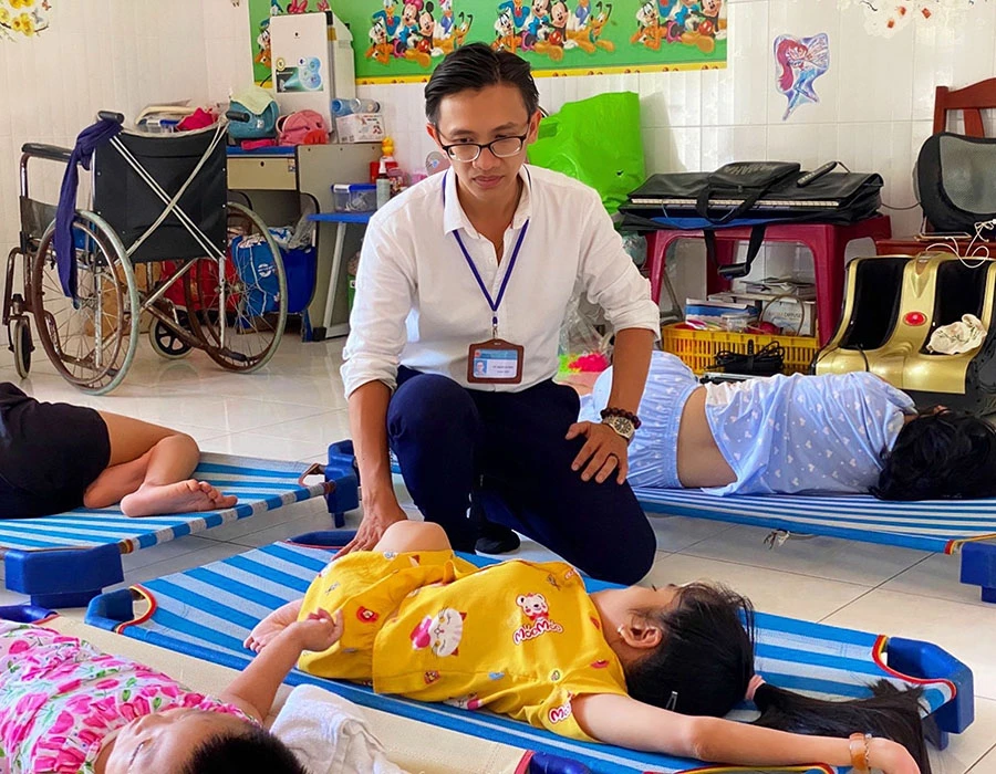 Thầy Vũ Minh Vương trong một lần tổ chức cho học sinh đến thăm trẻ em có hoàn cảnh đặc biệt, khuyết tật. Ảnh: NVCC.