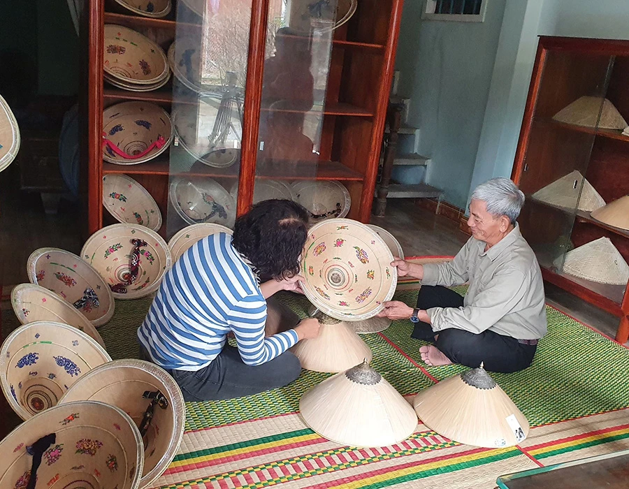 Cụ Lan giới thiệu nón ngựa với du khách. Ảnh: QN Cụ Lan giới thiệu nón ngựa với du khách. Ảnh: QN