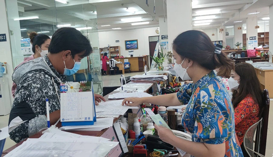 Người dân đến cơ quan BHXH TP.HCM làm các thủ tục BHXH, bảo hiểm y tế. Ảnh: NGUYỄN HIỀN