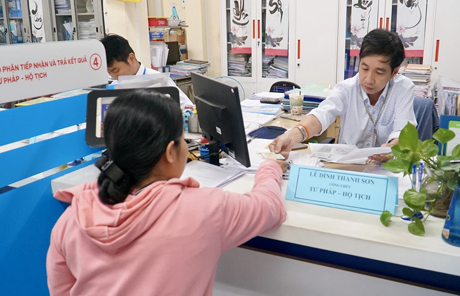 Anh Lê Đình Thanh Sơn, cán bộ UBND phường 10, quận Phú Nhuận, đang giải quyết thủ tục hành chính cho người dân. Ảnh: BẢO PHƯƠNG