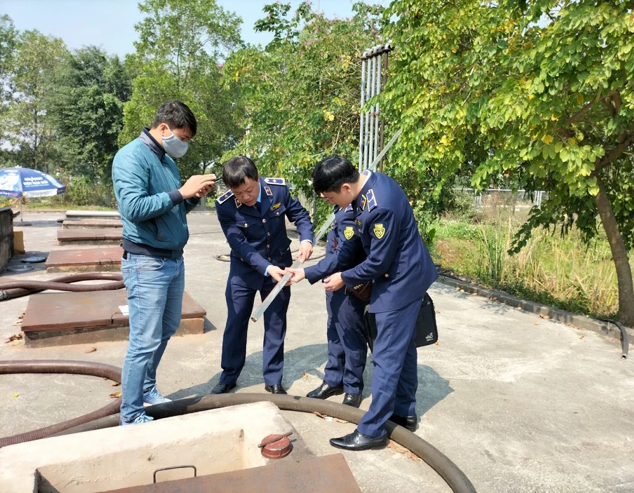 Lực lượng quản lý thị trường kiểm tra lượng xăng dầu tồn trong bể chứa của một doanh nghiệp bán lẻ xăng dầu. Ảnh: ALTT