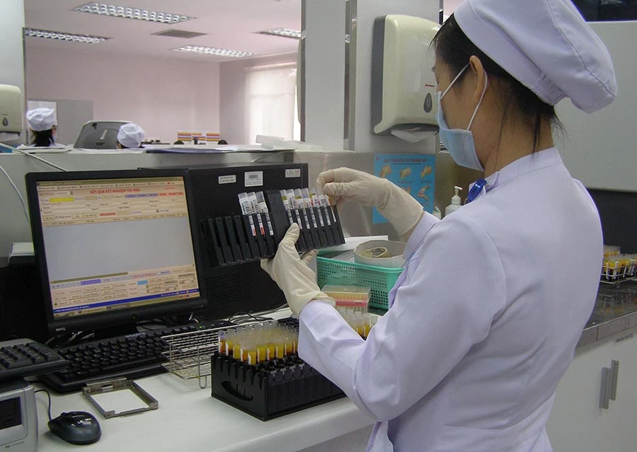 Nhân viên y tế đang xét nghiệm máu của bệnh nhân. Ảnh: TRẦN NGỌC