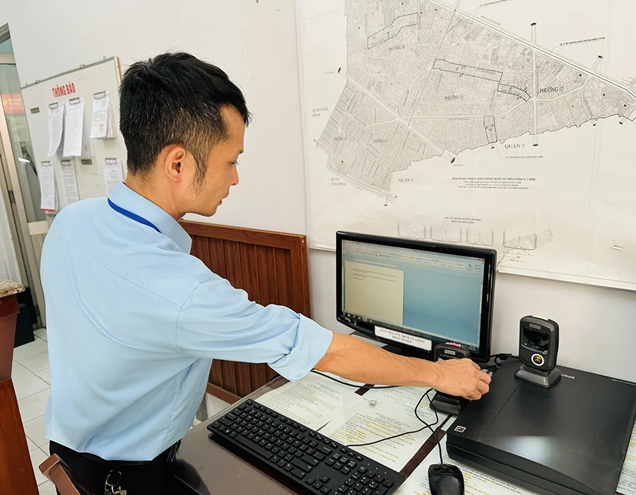 Cán bộ phường 11, quận Phú Nhuận, TP.HCM thực hiện quét mã vạch trên CCCD cho người dân. Ảnh: HUỲNH THƠ