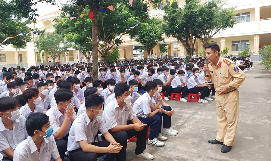 Cán bộ Đội CSGT trật tự Công an TP Tân An, Long An tuyên truyền cho học sinh các quy định đối với người điều khiển xe đạp điện, xe điện. Ảnh: H.DU