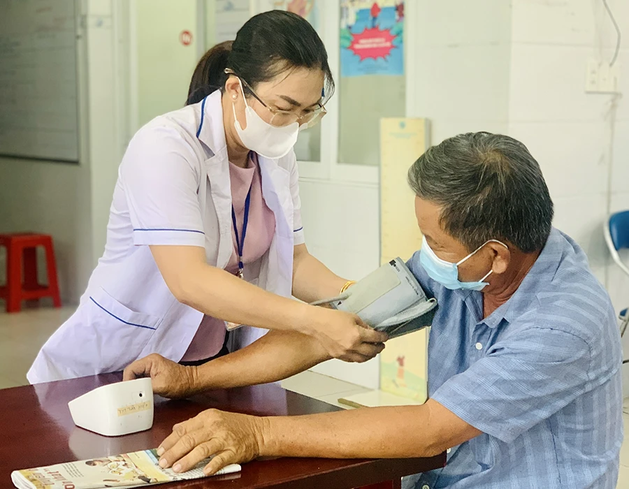 Nhân viên y tế cơ sở ở Trạm y tế xã Tân Hiệp, huyện Hóc Môn, TP.HCM khám chữa bệnh cho người dân. Ảnh: THẢO PHƯƠNG