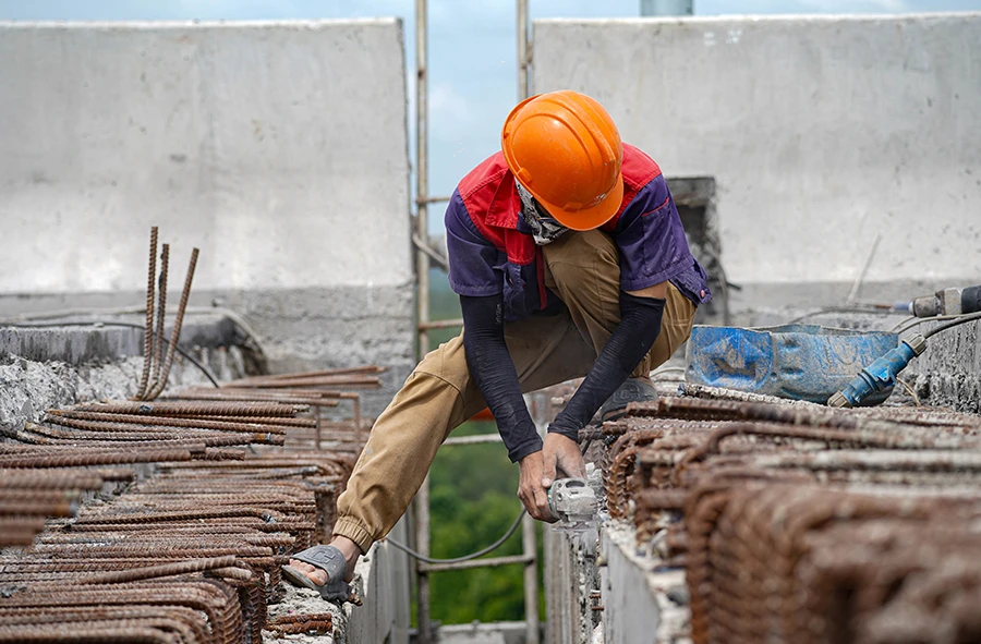 Công nhân thi công khe co giãn tại các điểm nối tiếp giáp mặt đường của cầu Nhơn Trạch. Ảnh: THUẬN VĂN