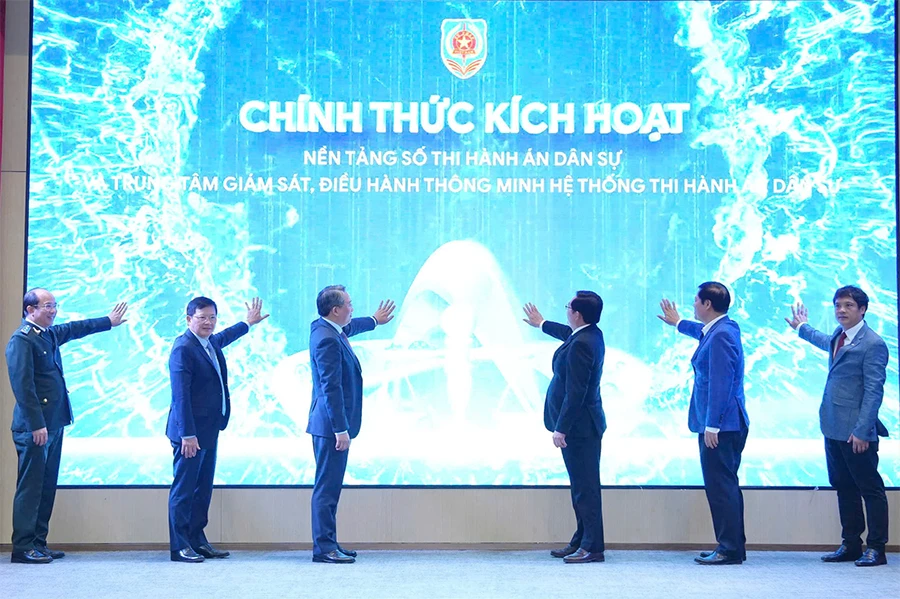 Lãnh đạo Chính phủ, Bộ Tư pháp, Cục Quản lý thi hành án dân sự và Tập đoàn công nghệ FPT nhấn nút kích hoạt khai trương nền tảng số thi hành án dân sự. Ảnh: LIÊN LÊ